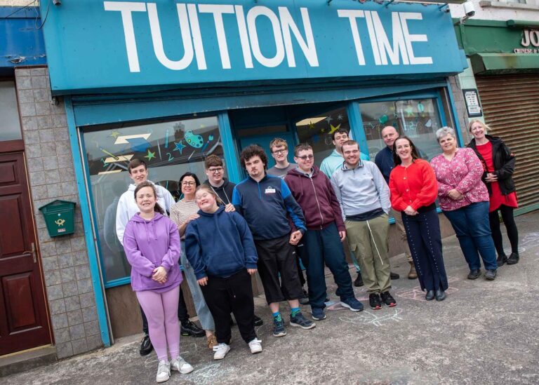 Smiles all round as Ready2Work Academy students stand outside Tuition Time with teachers and facilitators, celebrating the success of their showcase café event.