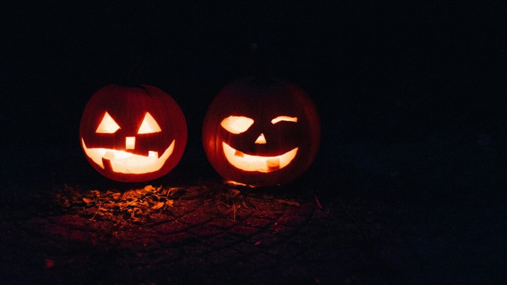 Two glowing carved pumpkins — illustrative Halloween stock photograph, not a photograph of the event